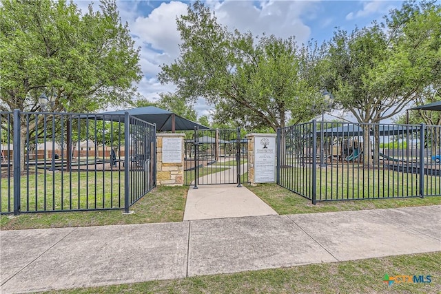 view of gate featuring a lawn and fence