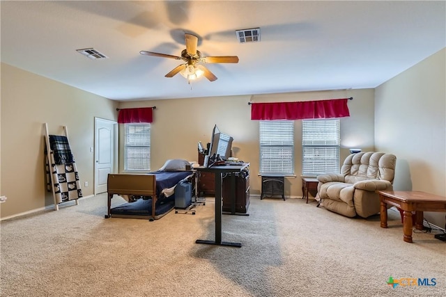 carpeted office space with baseboards, a ceiling fan, and visible vents