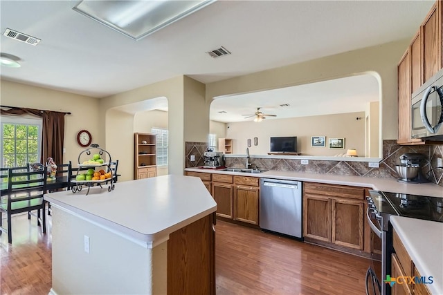 kitchen featuring a sink, stainless steel appliances, wood finished floors, and visible vents