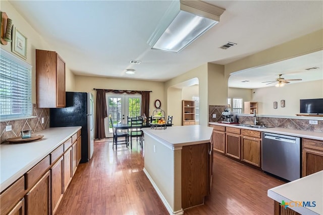 kitchen featuring brown cabinetry, a sink, appliances with stainless steel finishes, and wood finished floors
