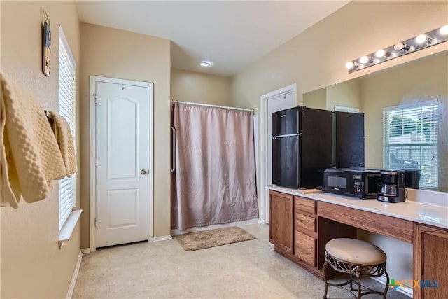 bathroom with baseboards, curtained shower, and vanity