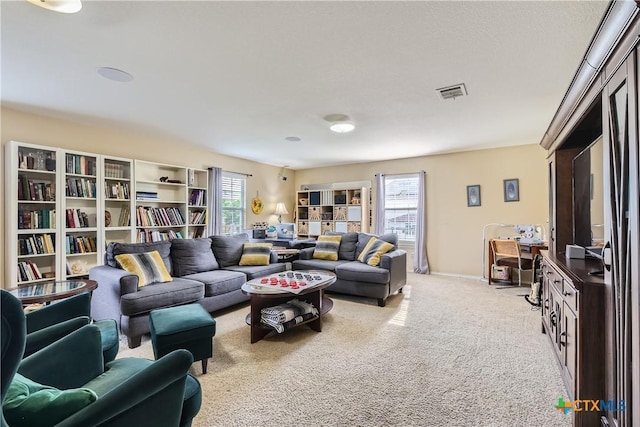 living room featuring carpet flooring, visible vents, and a wealth of natural light