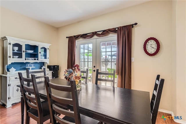 dining room featuring french doors and light wood finished floors