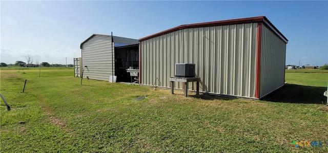 view of outbuilding with central AC and a yard