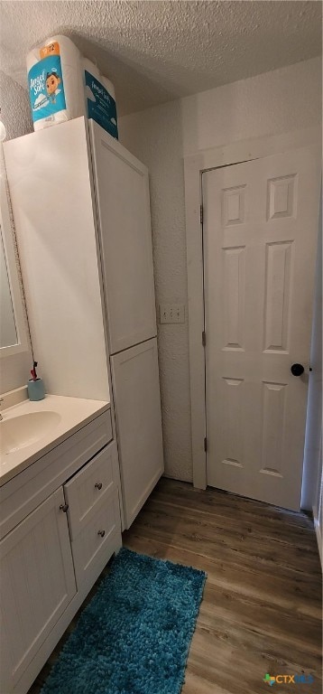 bathroom featuring hardwood / wood-style floors, vanity, and a textured ceiling