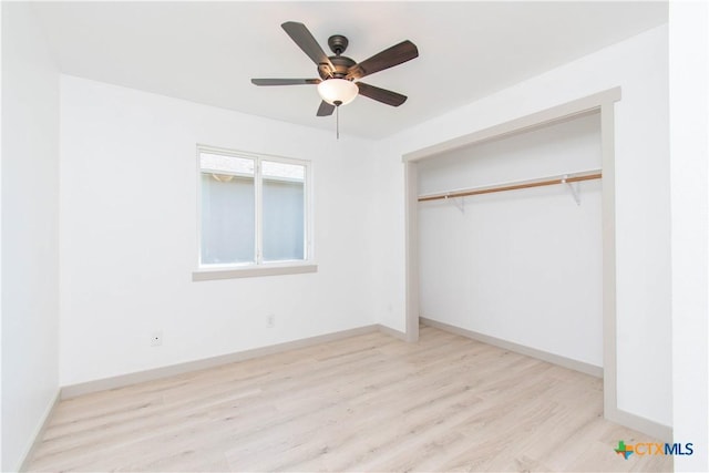 unfurnished bedroom featuring light wood-style floors, a closet, and baseboards