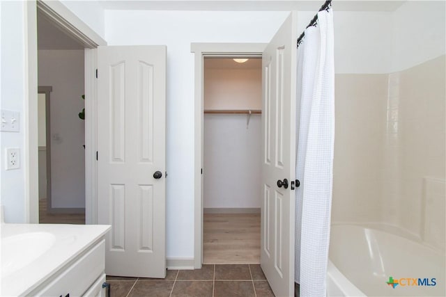 bathroom with vanity, baseboards, shower / bath combination with curtain, and tile patterned floors