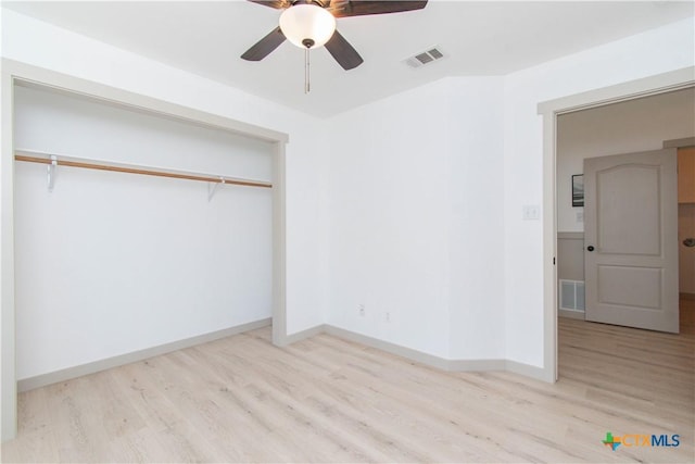 unfurnished bedroom featuring light wood-style flooring, a closet, visible vents, and baseboards