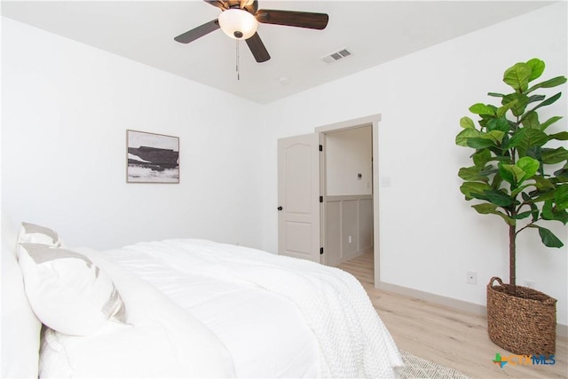 bedroom with ceiling fan, light wood-style flooring, and visible vents