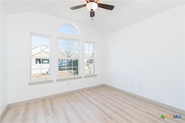 unfurnished room featuring baseboards, vaulted ceiling, light wood finished floors, and ceiling fan