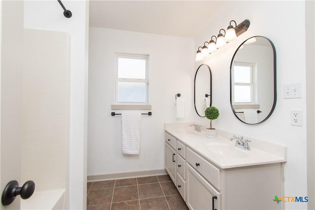 full bathroom featuring double vanity, tile patterned flooring, a sink, and baseboards