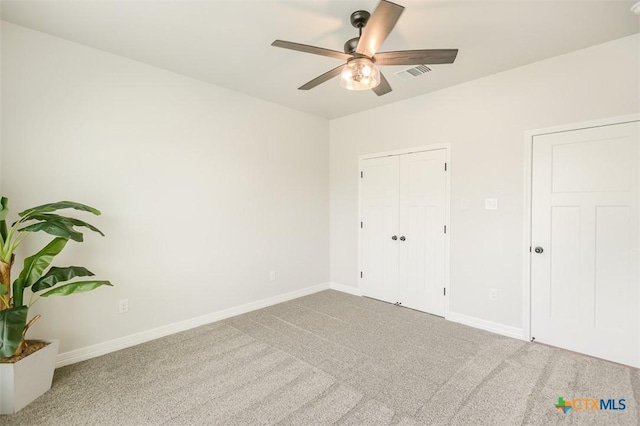 unfurnished bedroom with a closet, ceiling fan, visible vents, baseboards, and carpet floors
