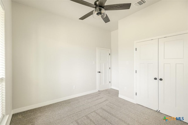 unfurnished bedroom with baseboards, visible vents, carpet floors, and a closet