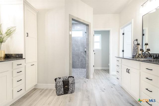 full bath featuring walk in shower, wood finished floors, and baseboards