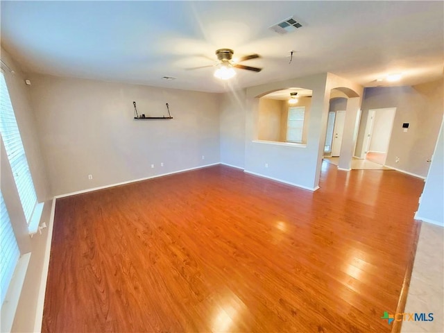 9200 Ashlyn Dr, Killeen, TX 76542 - unfurnished room featuring arched walkways, a ceiling fan, wood finished floors, and plenty of natural light
