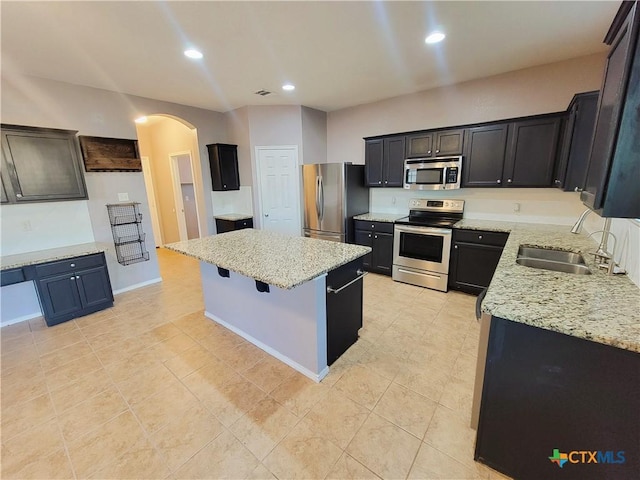 9200 Ashlyn Dr, Killeen, TX 76542 - kitchen with appliances with stainless steel finishes, arched walkways, a kitchen island, light stone countertops, and recessed lighting