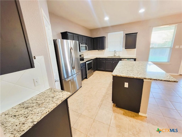 9200 Ashlyn Dr, Killeen, TX 76542 - kitchen with appliances with stainless steel finishes, light tile patterned flooring, a kitchen island, light stone counters, and recessed lighting