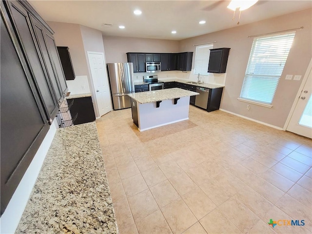 9200 Ashlyn Dr, Killeen, TX 76542 - kitchen with stainless steel appliances, a center island, light stone countertops, a kitchen breakfast bar, and recessed lighting