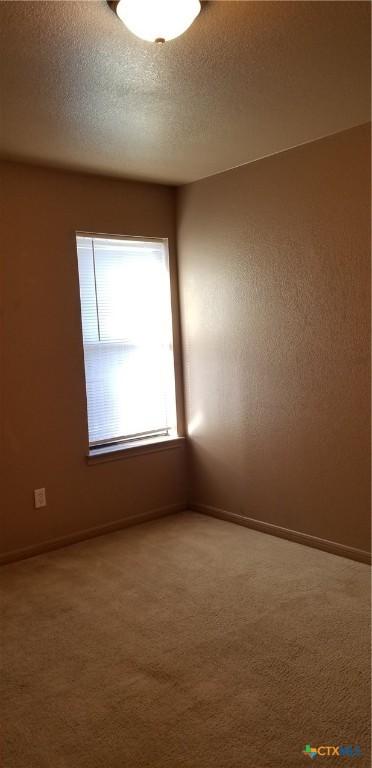 1207 Nicholas Cir, Killeen, TX 76542 - spare room with carpet flooring, baseboards, and a textured ceiling
