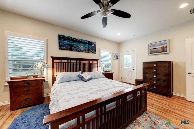 bedroom with light wood-type flooring, multiple windows, and ceiling fan