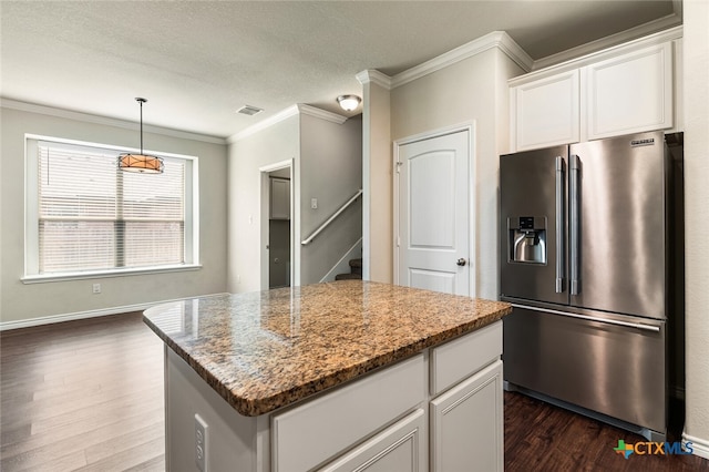 kitchen featuring white cabinetry, light stone countertops, a center island, stainless steel fridge, and dark hardwood / wood-style flooring