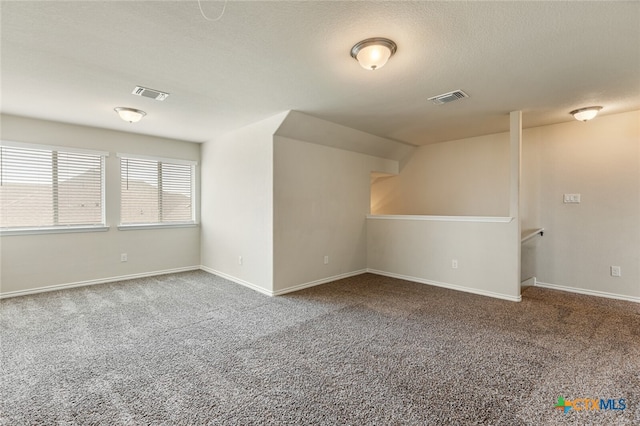 spare room with carpet and a textured ceiling