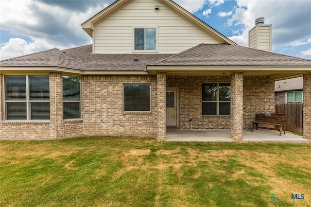 rear view of house featuring a patio and a lawn