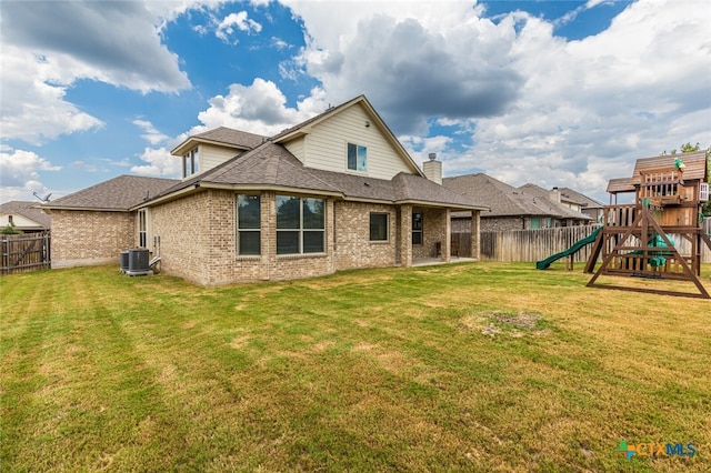 rear view of house with a playground, cooling unit, and a yard