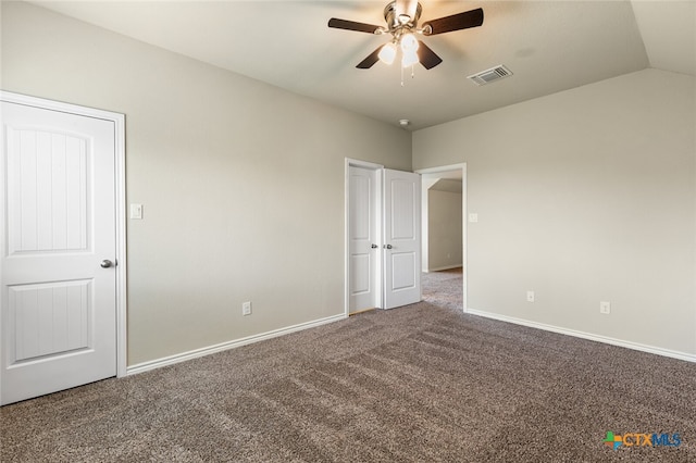 unfurnished bedroom featuring ceiling fan, vaulted ceiling, and carpet floors