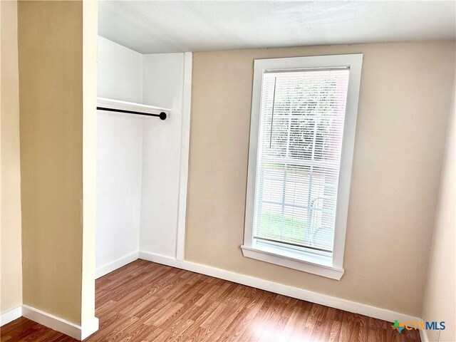 interior space with baseboards and wood finished floors