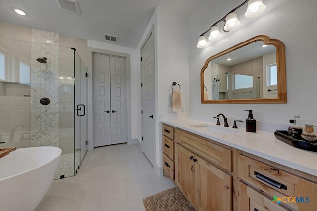 bathroom with vanity, a shower stall, tile patterned flooring, visible vents, and a freestanding bath