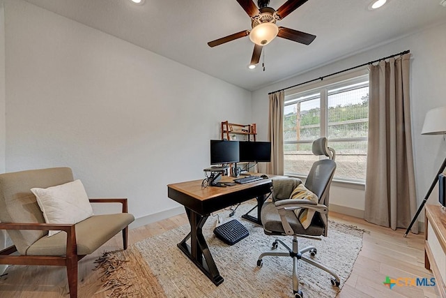 office space with baseboards, ceiling fan, and light wood-type flooring