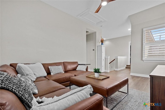 living room with light wood finished floors, attic access, and baseboards