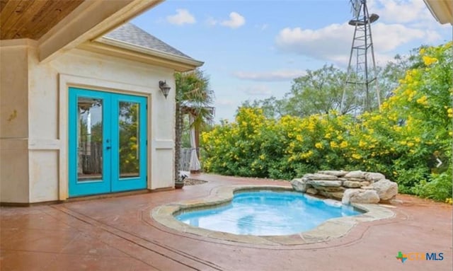 view of pool with french doors and a hot tub