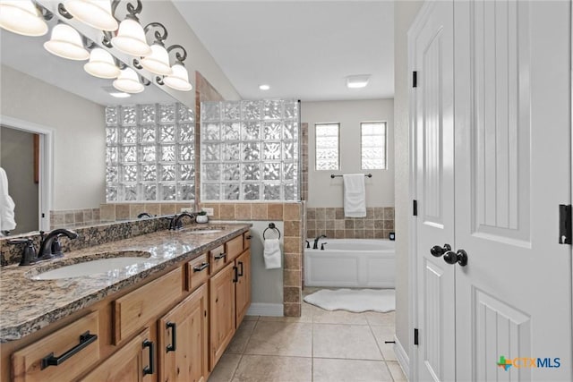 bathroom with a chandelier, a sink, a bath, and tile patterned floors