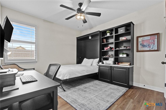 bedroom featuring ceiling fan, light wood finished floors, and baseboards