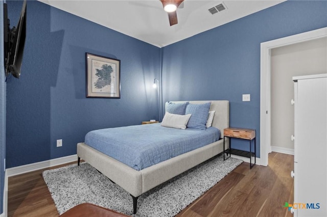 bedroom featuring visible vents, ceiling fan, baseboards, and wood finished floors