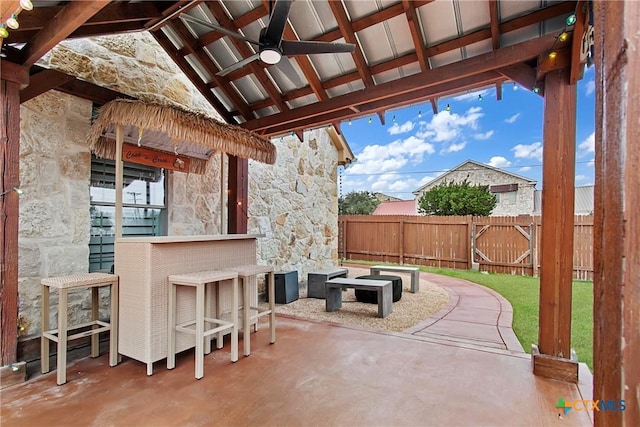 view of patio / terrace with outdoor dry bar, a gazebo, fence, and a ceiling fan