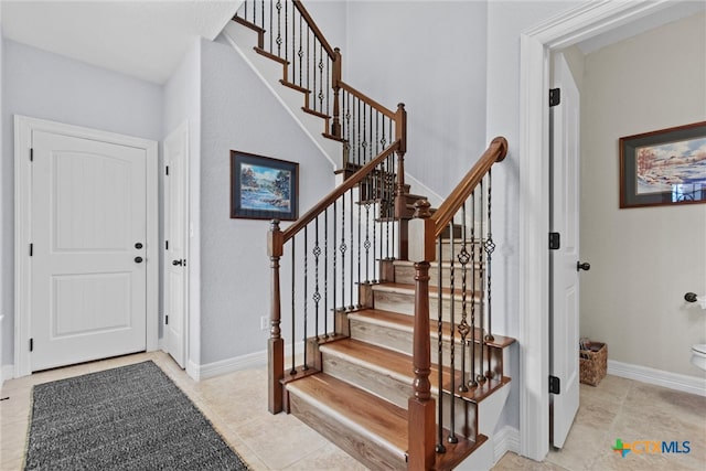 foyer with baseboards and light tile patterned floors