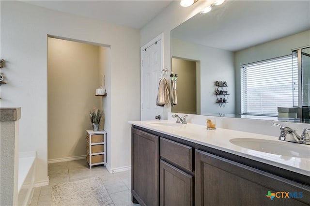 bathroom with a bathtub, vanity, and tile patterned floors