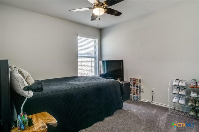 bedroom featuring ceiling fan and dark carpet