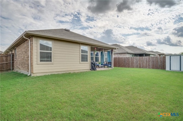 back of property with a shed and a yard