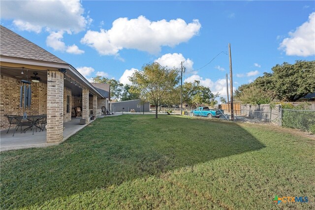 view of yard with ceiling fan and a patio