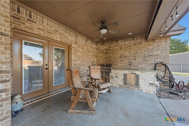 view of patio with ceiling fan, a grill, and sink