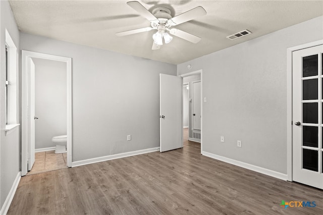 708 N 19th St, Copperas Cove, TX 76522 - unfurnished bedroom featuring wood finished floors, ensuite bathroom, and a ceiling fan