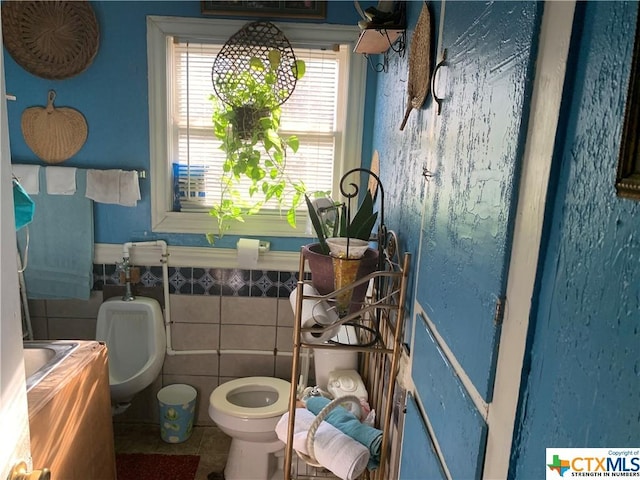 bathroom with tile patterned floors, a healthy amount of sunlight, tile walls, and toilet