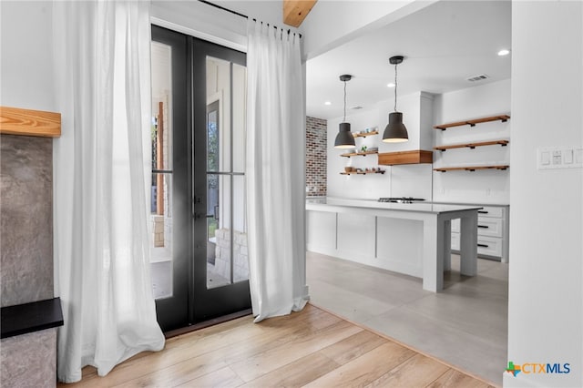 entrance foyer with beamed ceiling, light wood-type flooring, and french doors