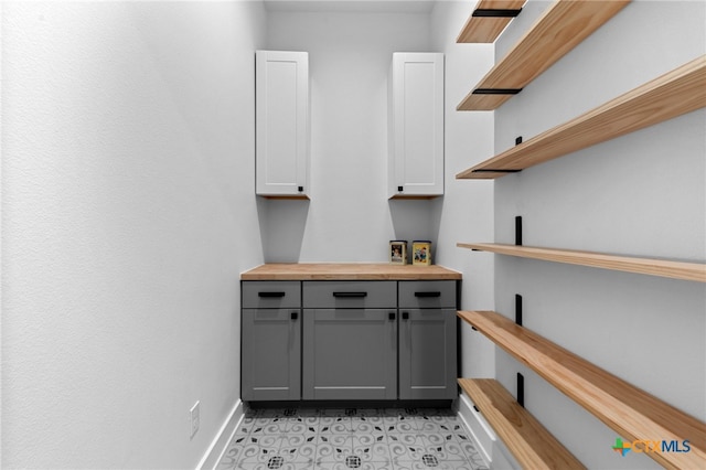 bar featuring gray cabinets, butcher block counters, and white cabinetry