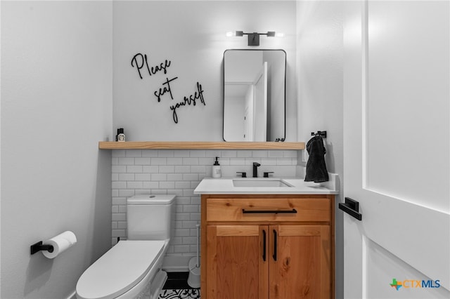 bathroom featuring tile patterned floors, vanity, toilet, and tile walls