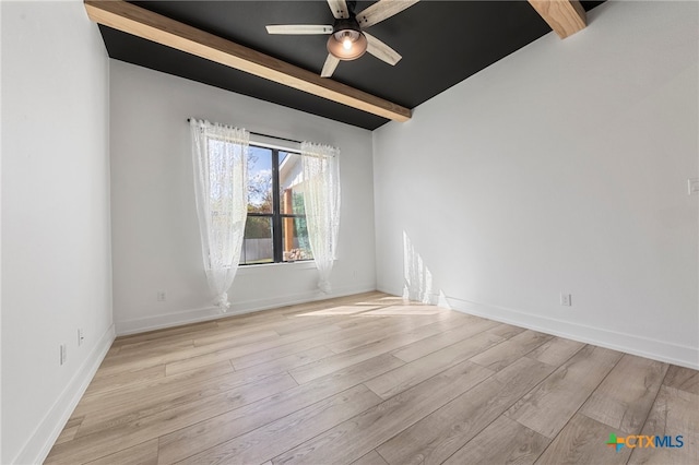 empty room with beam ceiling, light hardwood / wood-style floors, and ceiling fan